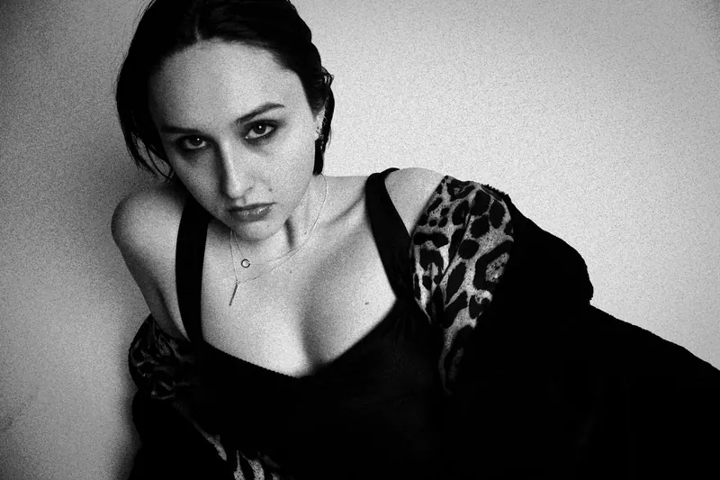 Alyssa looking up with a leopard-patterned jacket falling from the shoulders
