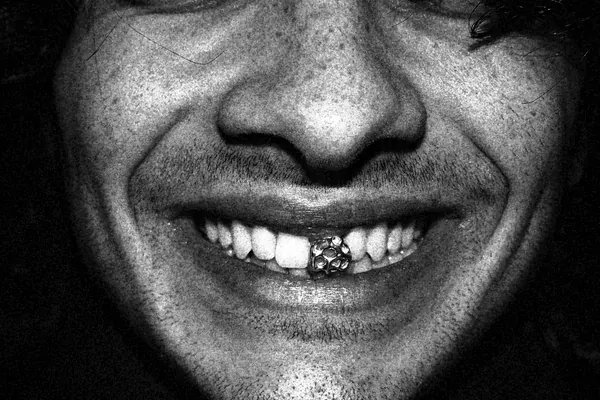 a man with a gem on his front tooth