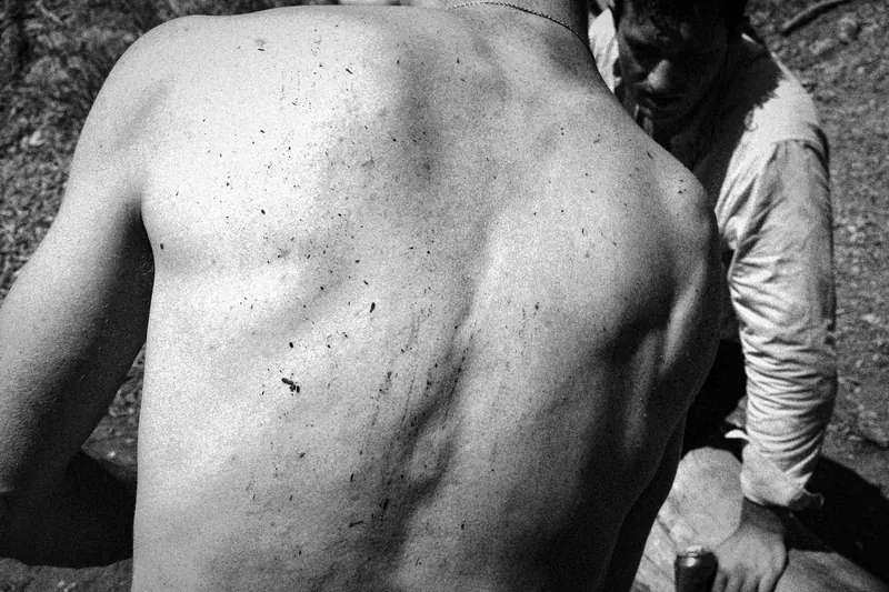 Close view of Max’s bare back with flecks of sand on the skin