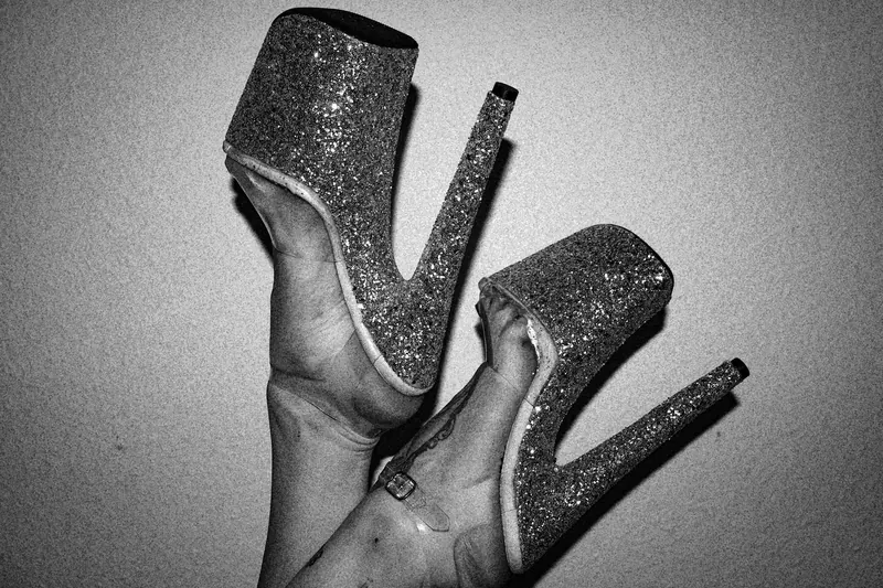 Gotho’s raised legs in glittering platform heels