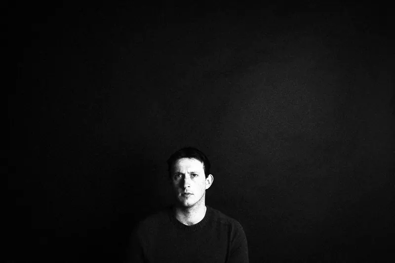 James small in the lower part of a wide, dark frame