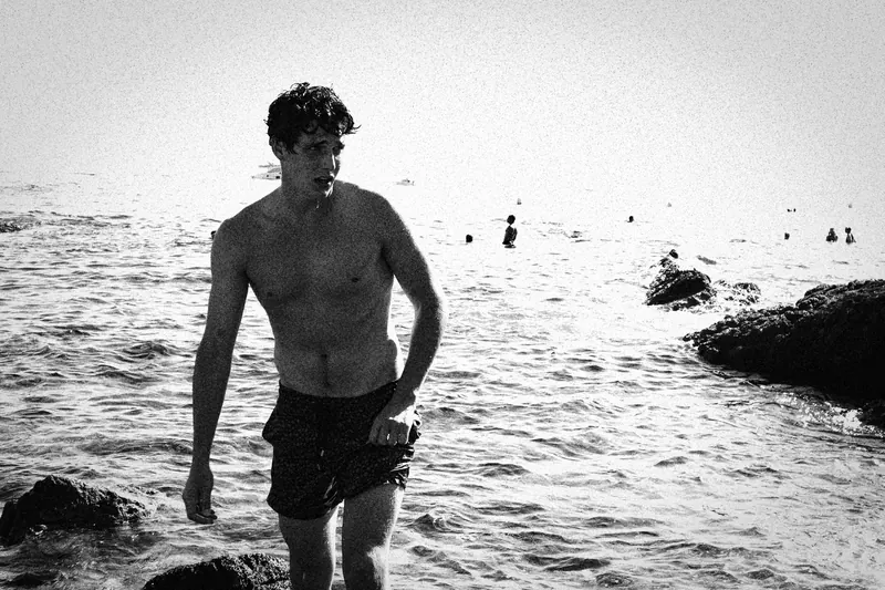Charlie walking out of the water beside rocks