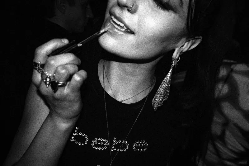 a woman applying lip gloss