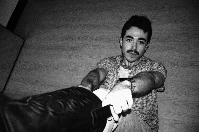 Tristan seated on the floor with both arms extended toward the camera