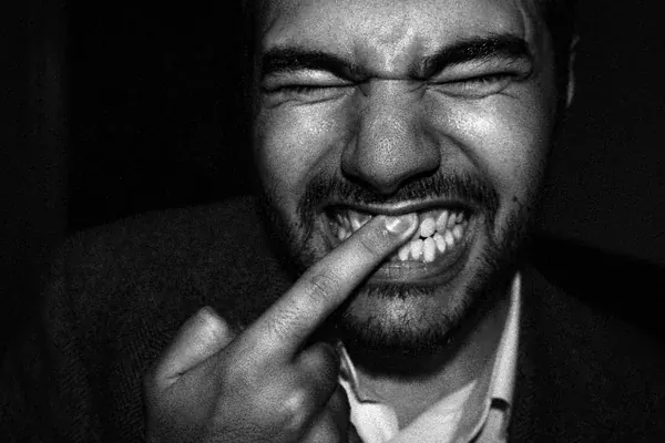 man rubbing his teeth