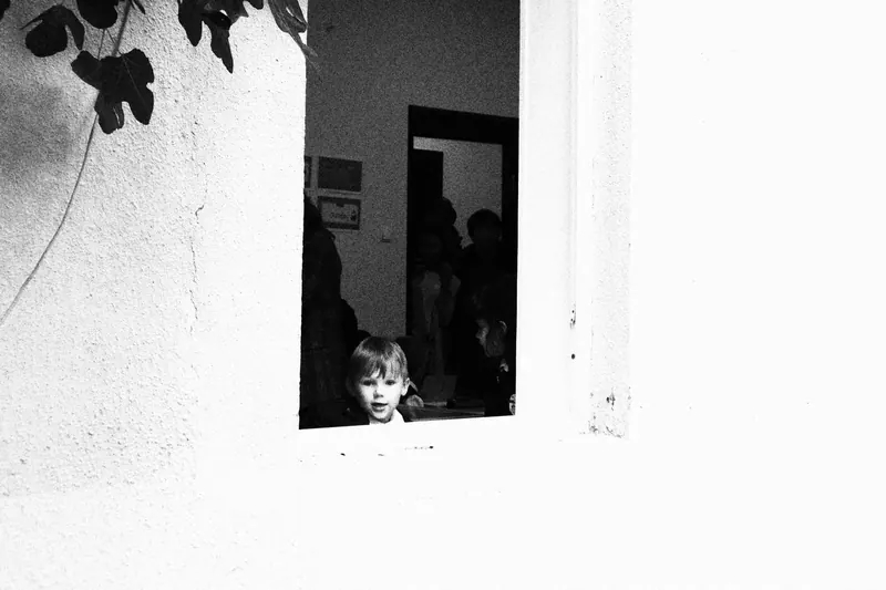 School boy looking through class window