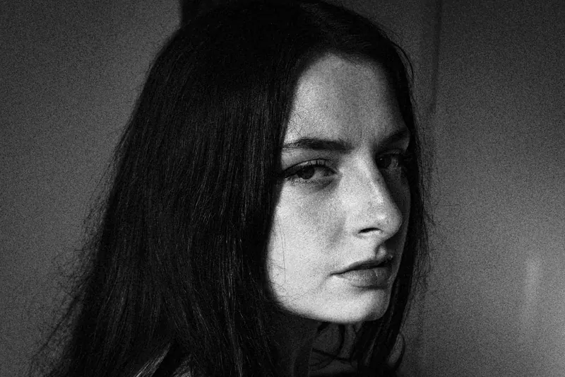 Magdalene turning toward the camera with long hair partly covering the face